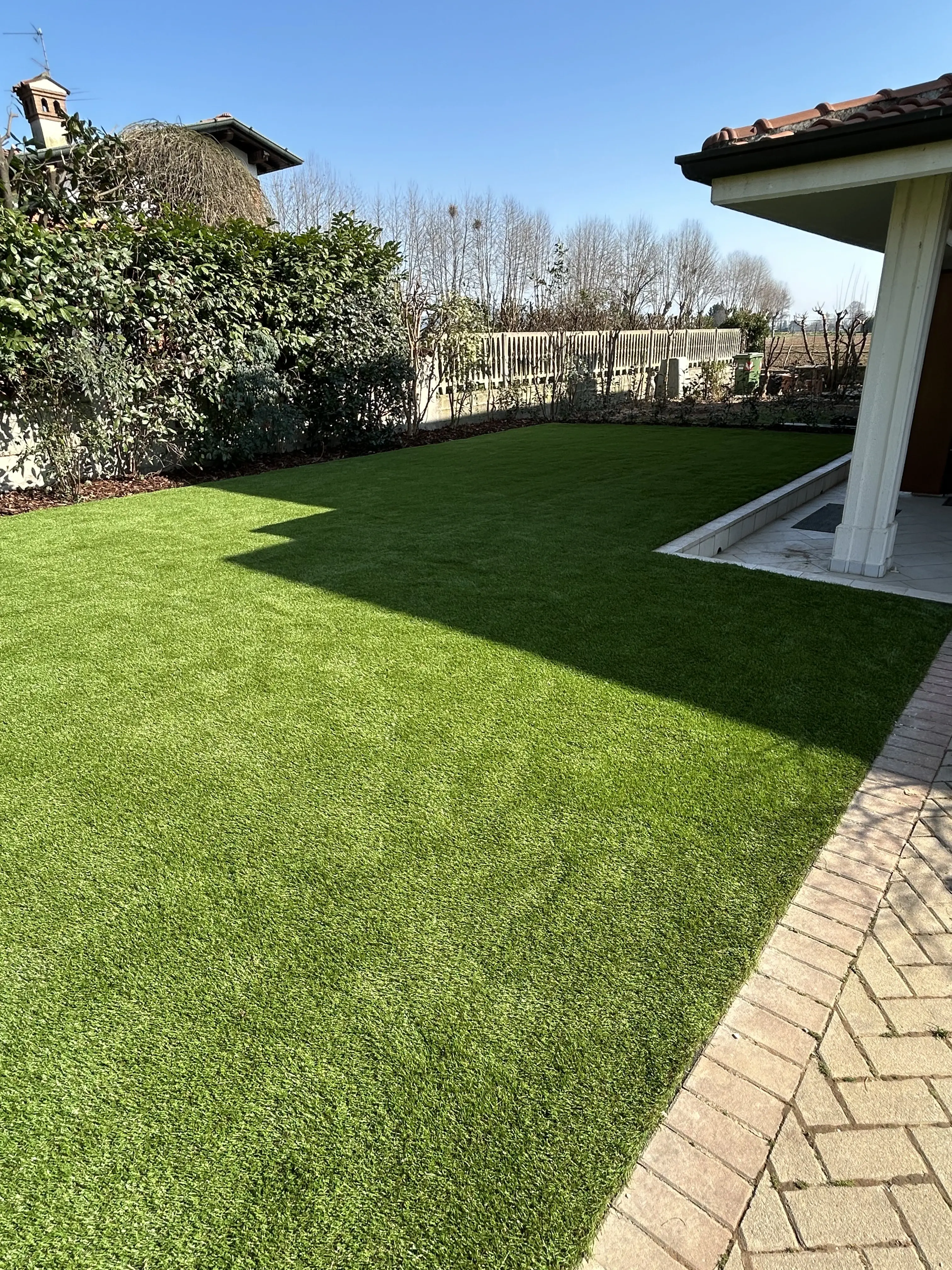 Posa professionale erba sintetica per giardino residenziale in provincia di Brescia.